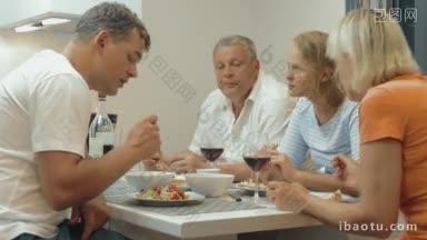 年轻<strong>人和</strong>老年人在家庭聚餐时，喝着红酒，玻璃杯叮当作响